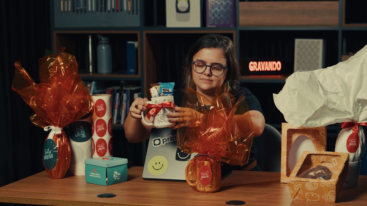 Emily, da Printi, montando kit de Páscoa com caneca 440ml personalizada, adesivos ovais e embalagens para venda.