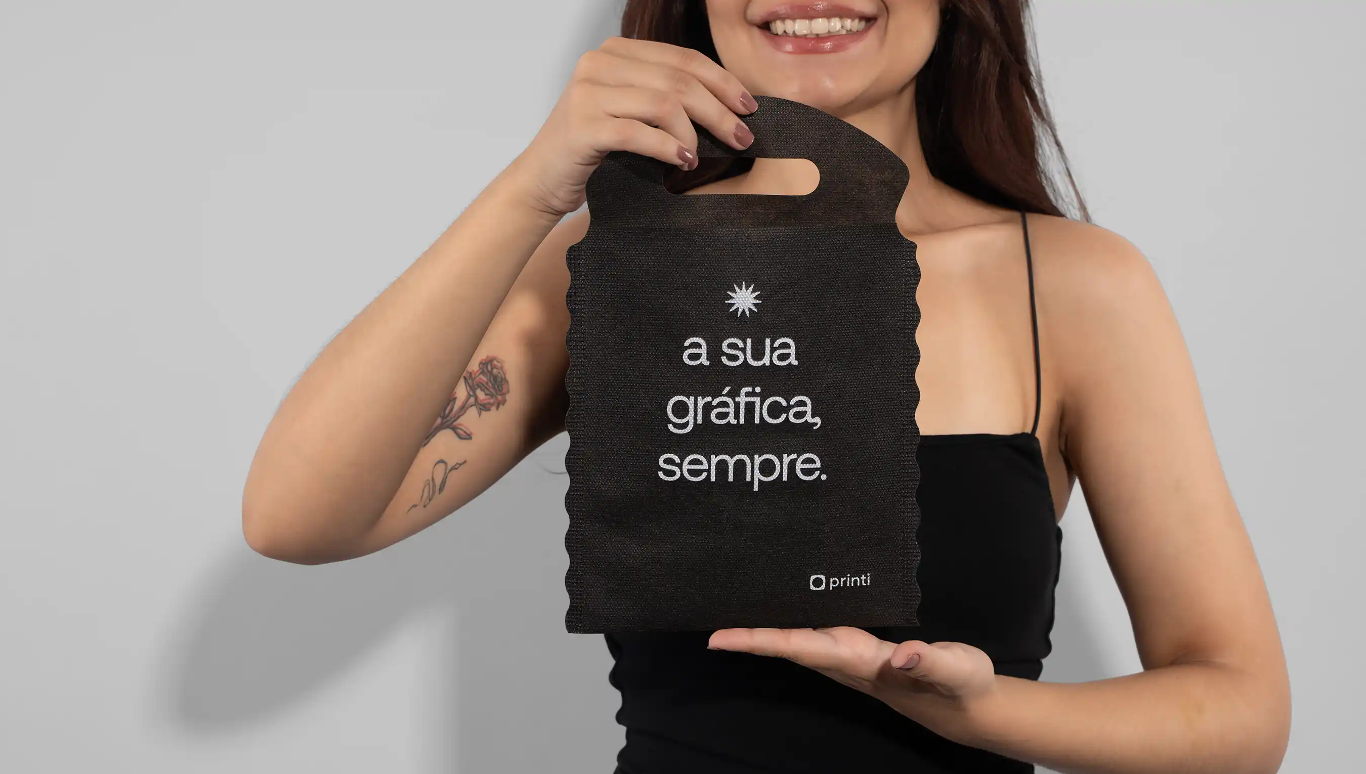 Mulher sorrindo segurando lixeira para carro na cor preta com slogan da Printi