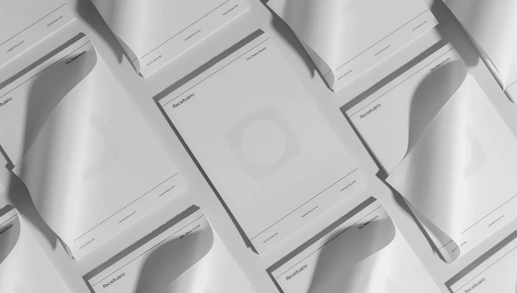 Composição de diversos blocos de receituário médico personalizados espalhados sobre superfície neutra, destacando design clean com o nome Dra. Maria Souza.